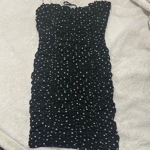 This is a strapless black dress with polkadots